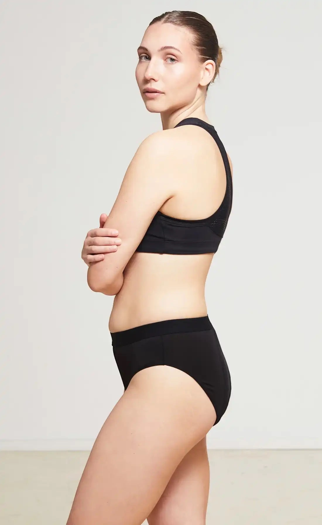 Care Design black low-waist incontinence briefs with built-in barrier, made from a blend of nylon, polyester, viscose, and spandex.