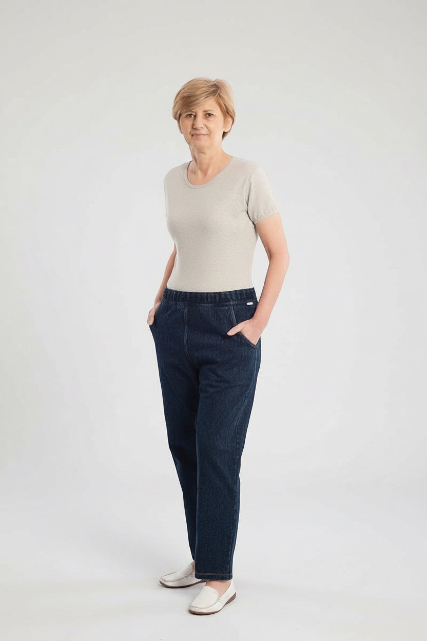 Care Design unisex denim overalls with light grey short-sleeve t-shirt, elastic ankles, and zip front. Cotton-polyester blend.
