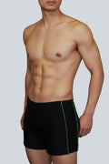 Care Design Florida black men's swim trunks with green side stripe, high waist, and inner pocket for stoma bag.