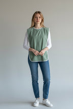 Care Design adult bib in light green terry cloth with white trim. Waterproof and absorbent for mealtime protection.