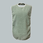 Care Design adult bib in sage green terry cloth with white trim. Waterproof and washable for mealtime protection.